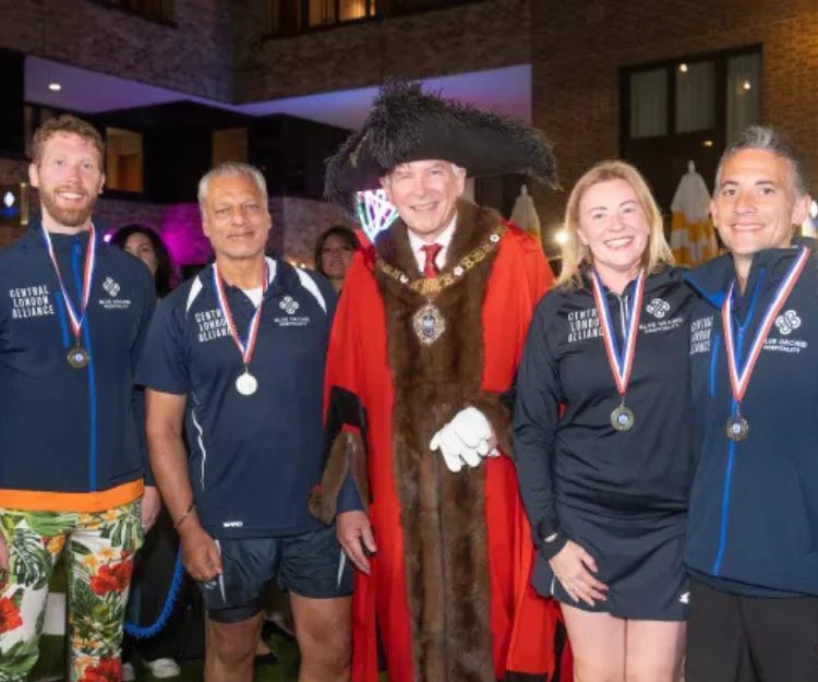 The 'awesome foursome' padel players wearing medals, pose with a City of London lord mayor in ceremonial robes and chain, celebrating their Guinness World Record win for Longest Marathon Playing Padel