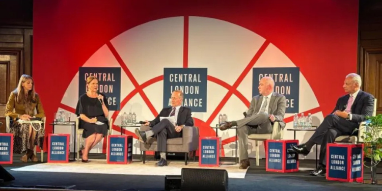 Five panelists seated in a row of armchairs on stage, mid-discussion, in front of a red and white 'Central London Alliance' backdrop with water bottles on side tables